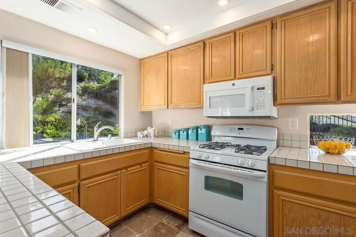1501 Promontory Ridge Way Vista, CA 92081 - Photo 7 of 22 a kitchen with a stove a sink and a window