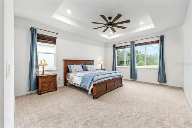 a bedroom with a large bed and a chandelier