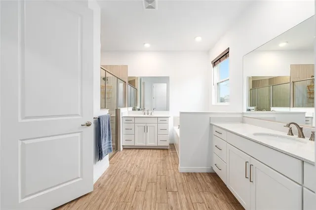 a kitchen with a sink cabinets wooden floor and stainless steel appliances