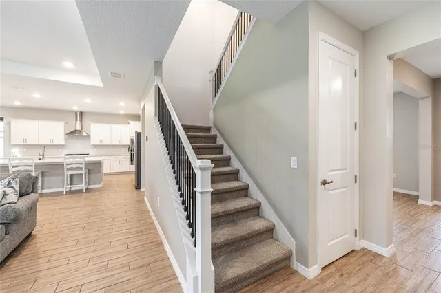 a view of a kitchen with wooden floor and stairs