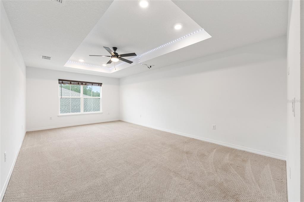 6488 Southwest 78th Court Ocala, FL 34474 - Photo 27 of 40 an empty room with windows and ceiling fan