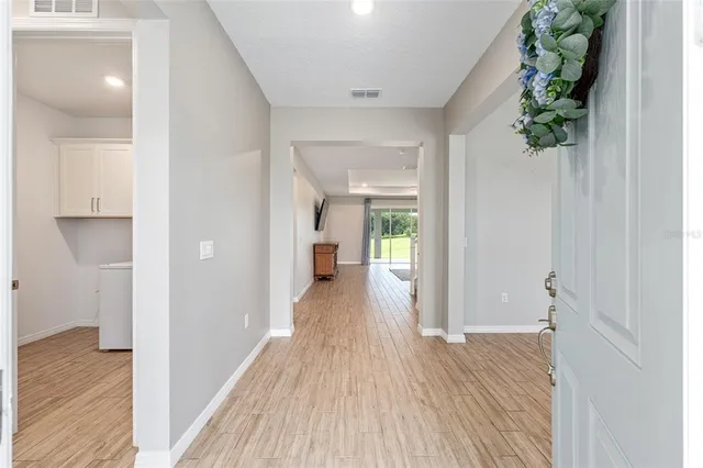 a view of a hallway with wooden floor