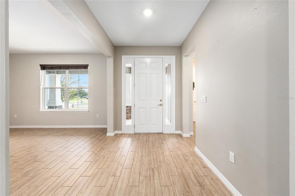6488 Southwest 78th Court Ocala, FL 34474 - Photo 4 of 40 an empty room with wooden floor and windows