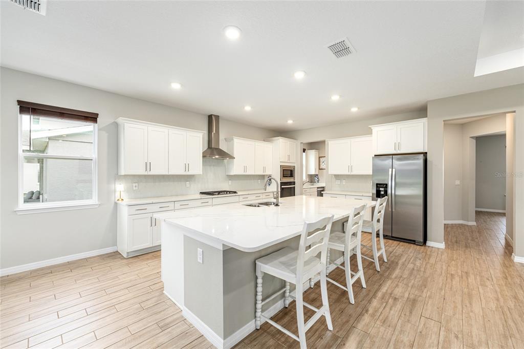 6488 Southwest 78th Court Ocala, FL 34474 - Photo 10 of 40 a kitchen with a dining table chairs wooden floor cabinets and stainless steel appliances