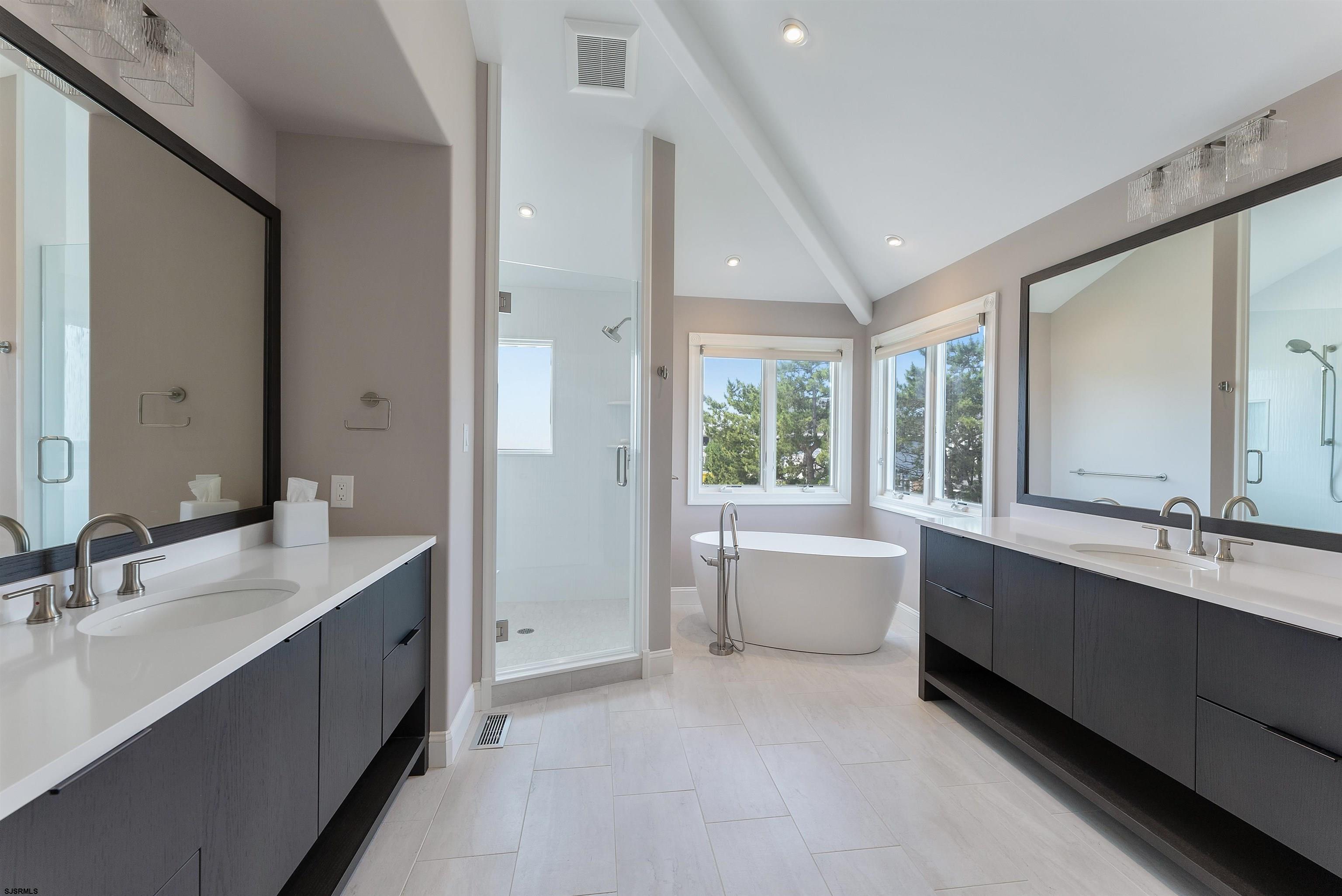 11901 2nd Avenue Stone Harbor, NJ 08247 - Photo 35 of 40 a large white bathroom with a large tub sink shower and mirror