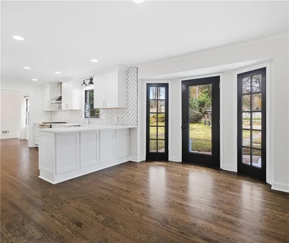 a view of large kitchen with wooden floor and a window