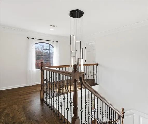 a view of staircase with railing and a chandelier