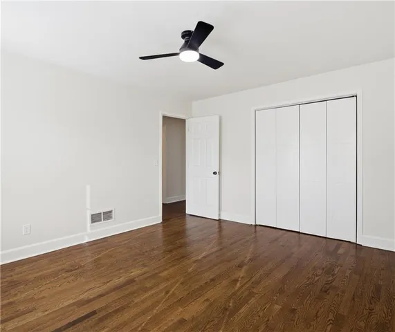 a view of an empty room with wooden floor