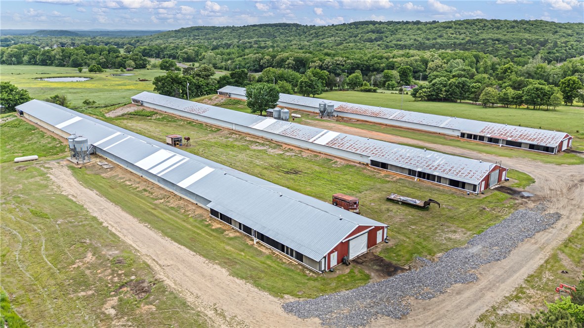 Three extensive agricultural buildings with metal roofs and red end walls