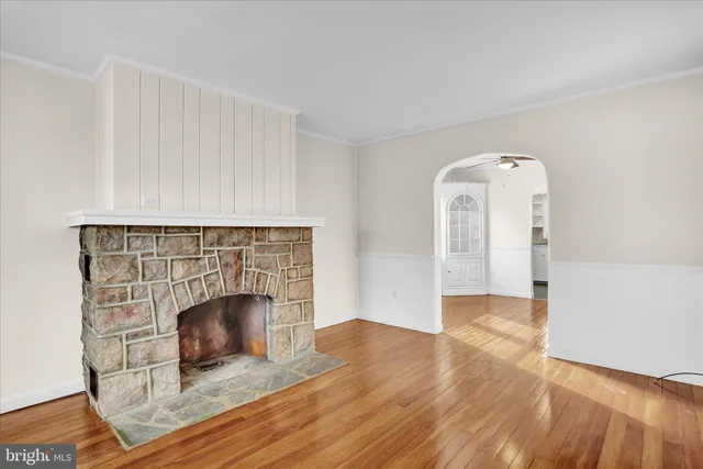an empty room with wooden floor and fireplace
