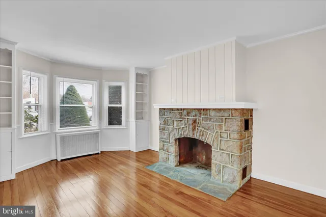 a view of empty room with wooden floor and fireplace