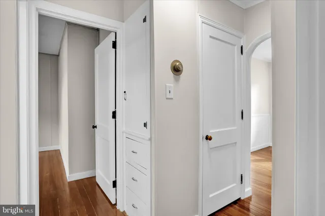 a view of a hallway with wooden floor and closet