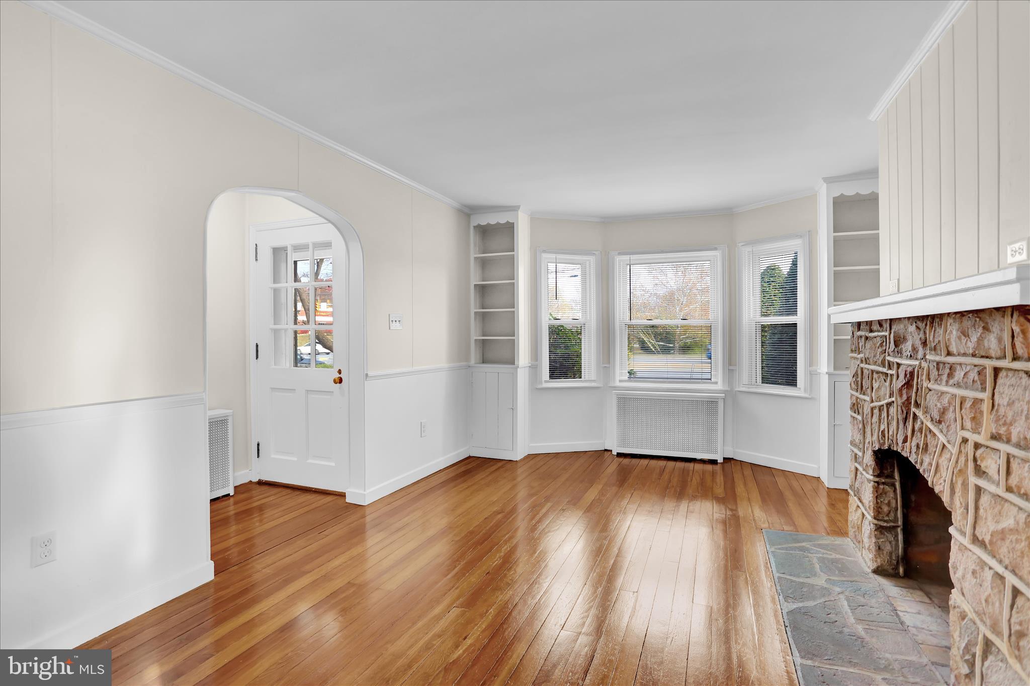 4710 Perkiomen Avenue Reading, PA 19606 - Photo 9 of 39 an empty room with wooden floor and a fireplace