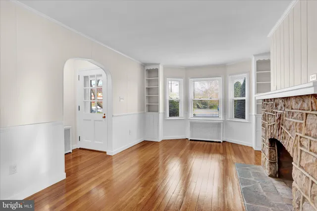 an empty room with wooden floor and a fireplace