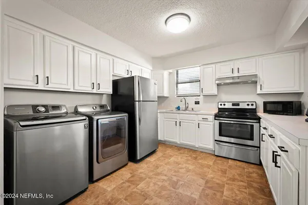 a kitchen with a refrigerator sink and cabinets