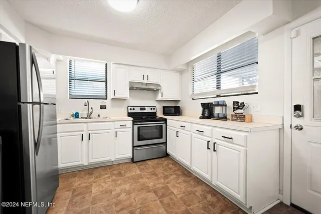a kitchen with white cabinets and white appliances