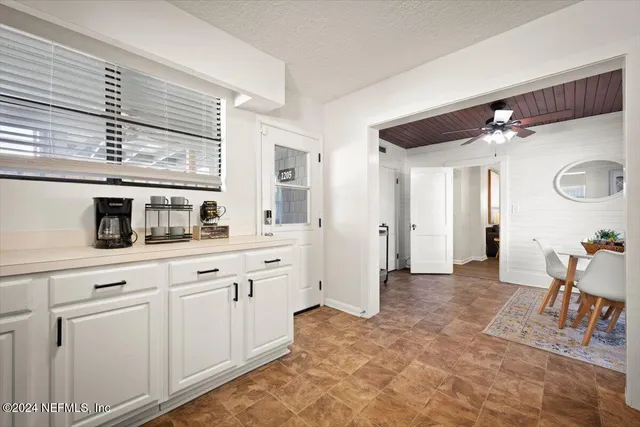 a kitchen with white cabinets and sink