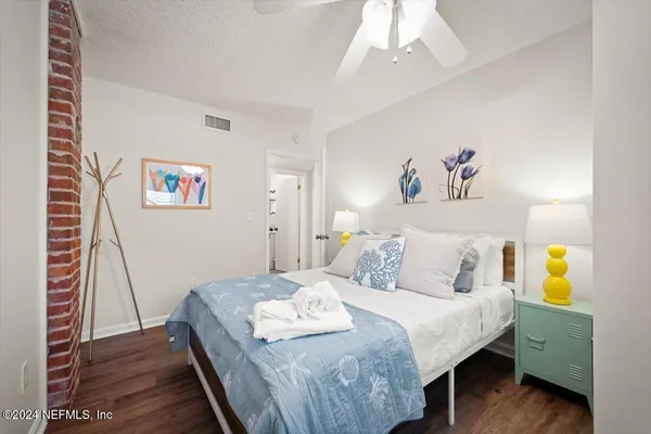 a bedroom with a bed and wooden floor