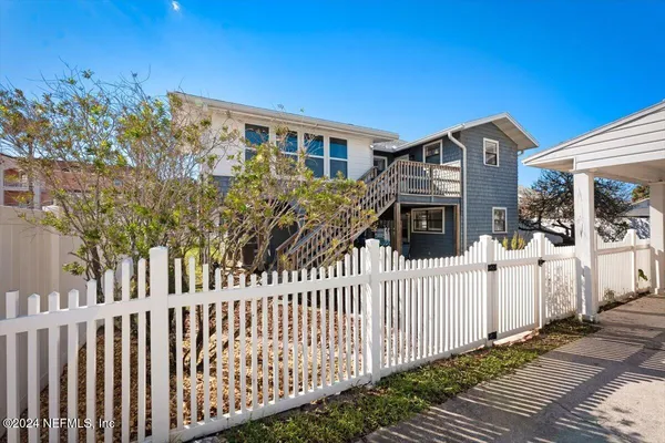 a view of a house with wooden fence