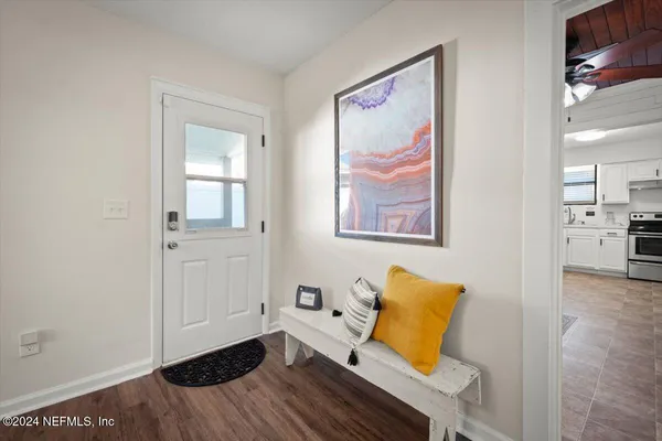a view of a livingroom with wooden floor and a workspace