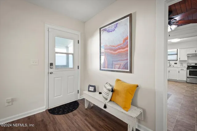 a view of a livingroom with wooden floor and a workspace