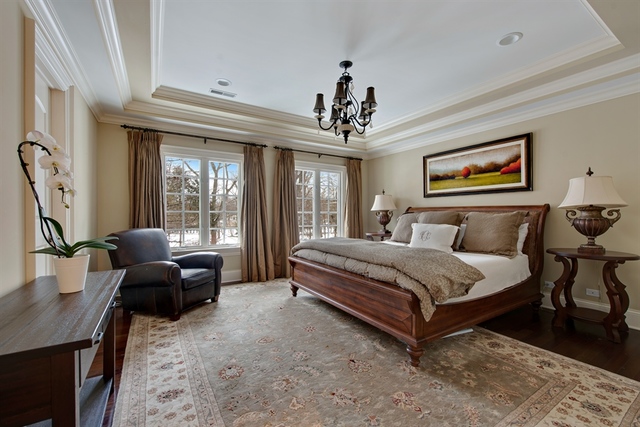 98 Woodley Road Winnetka, IL 60093 - Photo 11 of 21 a spacious bedroom with a bed and a chandelier