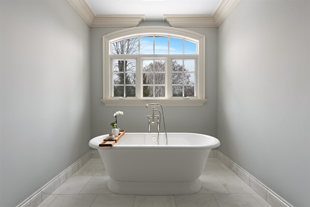 98 Woodley Road Winnetka, IL 60093 - Photo 8 of 21 a white bath tub sitting in a bathroom next to a window