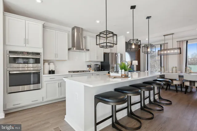 a kitchen with stainless steel appliances granite countertop a sink a stove and a wooden floors