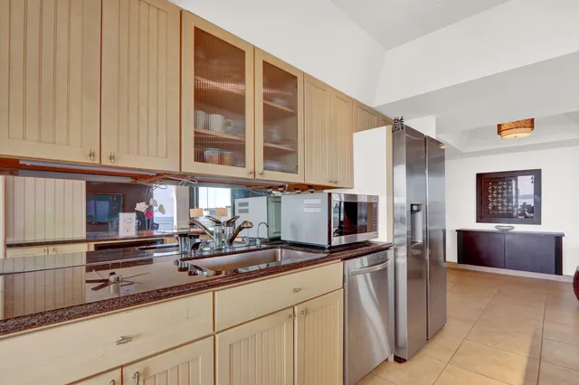 a kitchen with stainless steel appliances granite countertop a sink and a refrigerator
