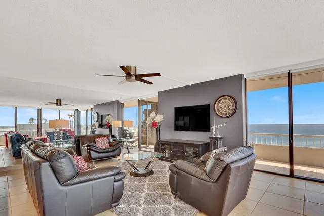 a living room with furniture a floor to ceiling window and a table