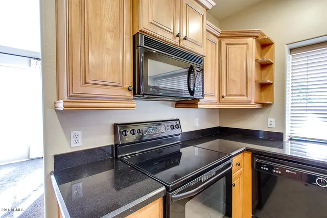 a kitchen with wooden cabinets and a stove top oven