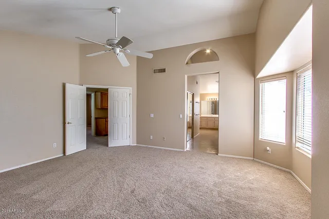 a view of empty room with window and ceiling fan