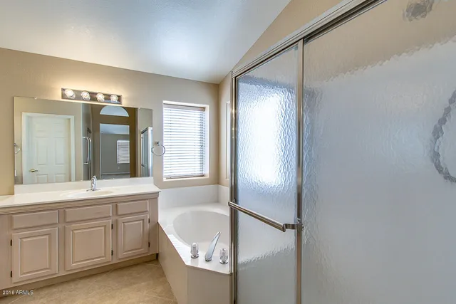 a spacious bathroom with a double vanity sink a mirror and a bathtub