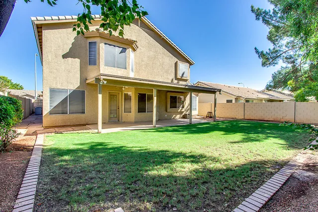 a view of a house with backyard sitting area and garden