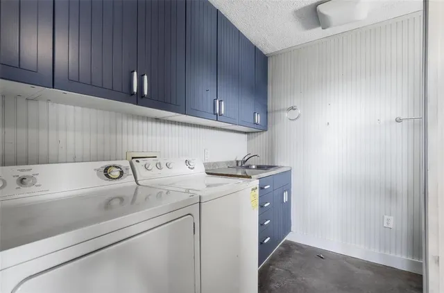 a utility room with cabinets washer and dryer