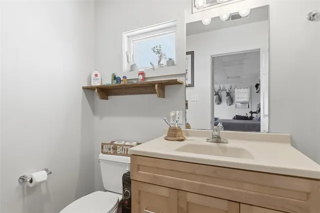 a bathroom with a sink mirror and toilet