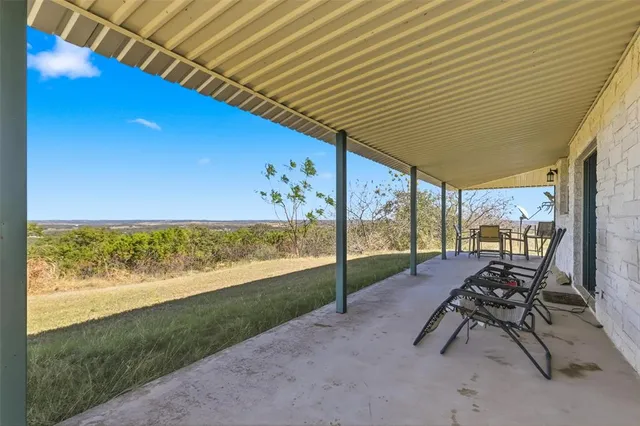 a view of a patio with a table and chairs under an umbrella