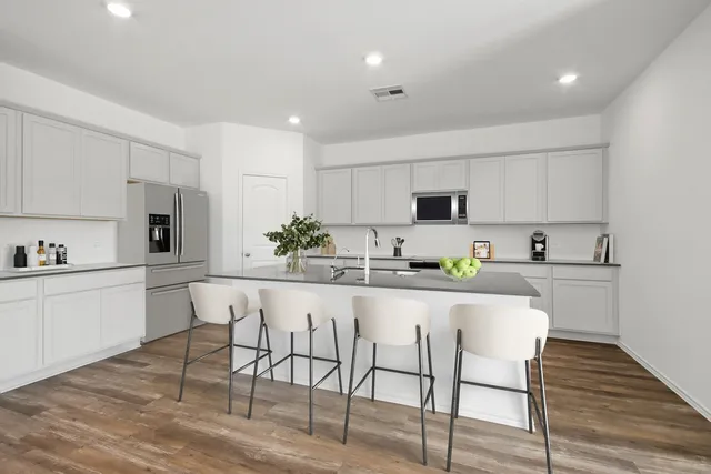 a kitchen with white cabinets and white appliances