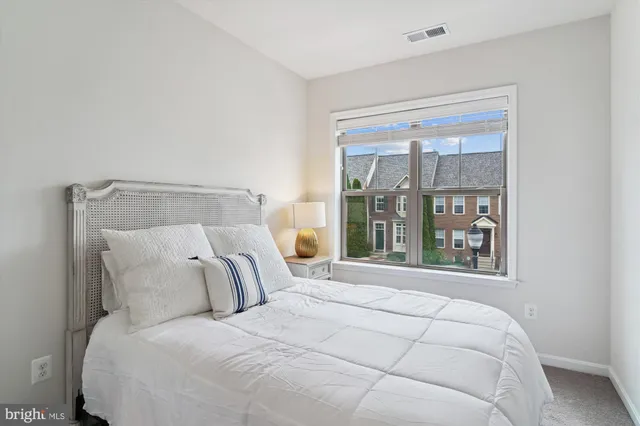 a large bed sitting in a bedroom next to a window