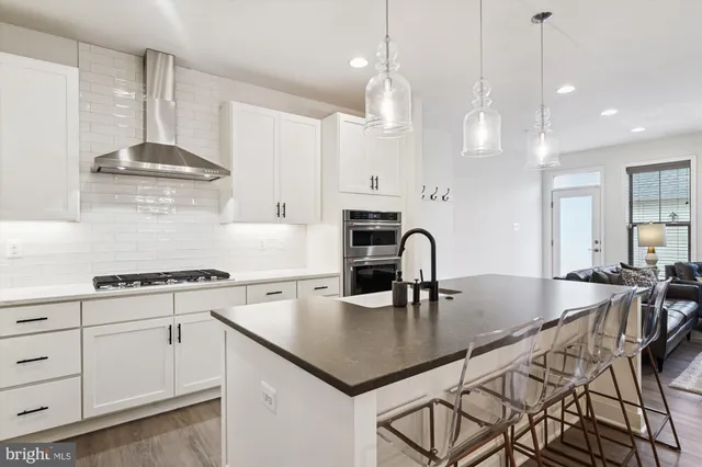 a kitchen with kitchen island granite countertop a table chairs sink and cabinets
