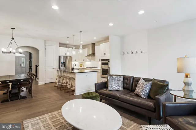 a living room with stainless steel appliances furniture and a view of kitchen