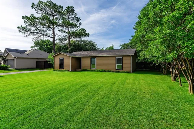 a view of a house with a yard and tree