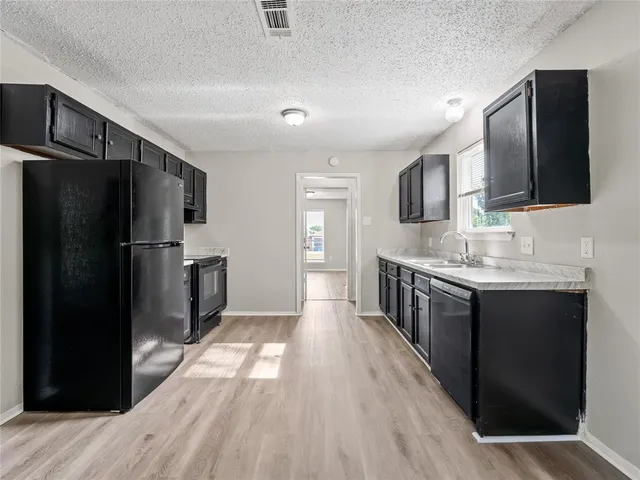 a kitchen with stainless steel appliances granite countertop a refrigerator and a sink