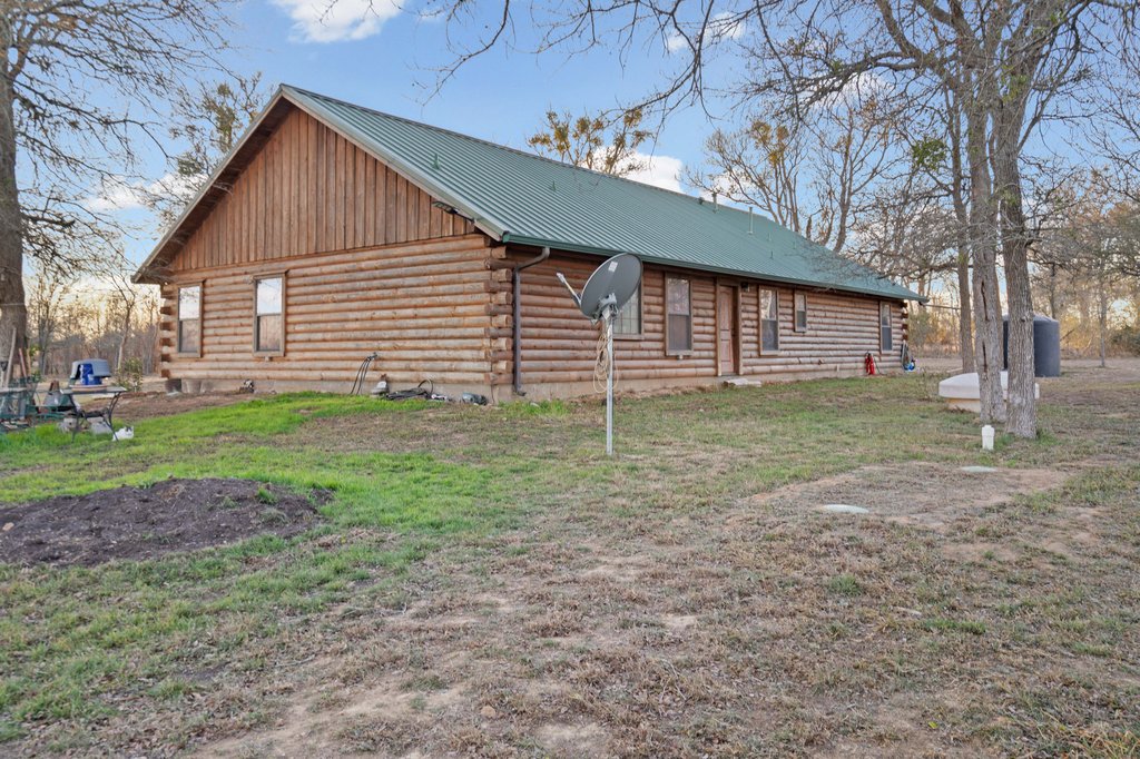 1843 Farm To Market 969 Elgin, TX 78621 - Photo 21 of 28 a backyard of a house with plants and large tree