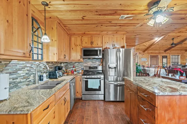 a kitchen with stainless steel appliances granite countertop a sink stove and refrigerator