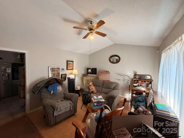 a living room with furniture a ceiling fan and a window
