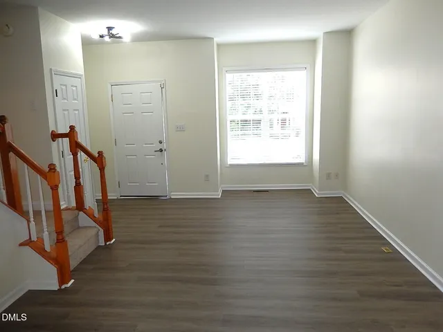 a view of a hallway with wooden floor and staircase
