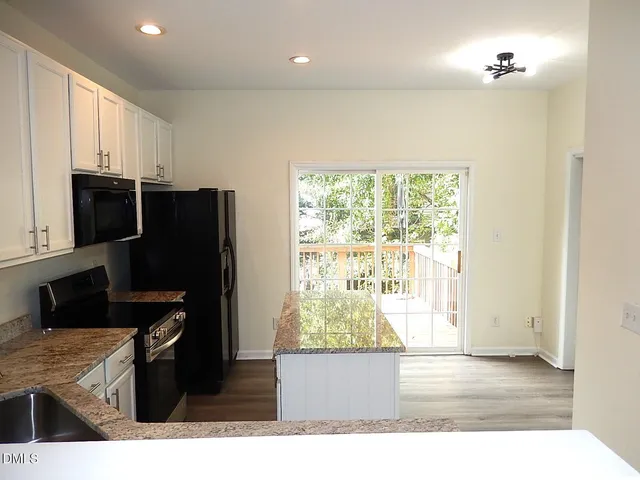 a kitchen with stainless steel appliances granite countertop a refrigerator and a stove