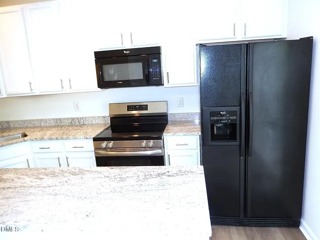 a kitchen with a refrigerator and a stove