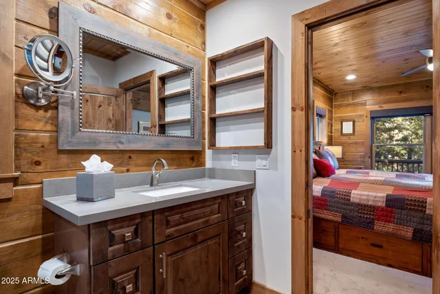 a bathroom with a granite countertop sink a toilet a mirror and shower